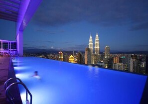 A rooftop infinity pool with a city skyline view, including the Petronas Towers. - Best Homestay (Kuala Lumpur)