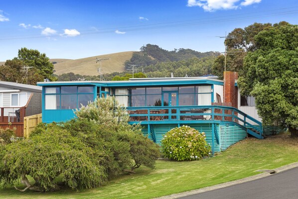 A two-story building with a blue exterior, a balcony, and a staircase leading to the upper floor.