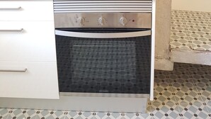Eine Küche mit Einbauofen, Toaster und Dunstabzugshaube aus Edelstahl.