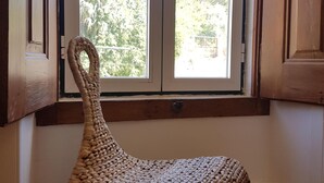 Ein gewebter Stuhl in einer Ecke mit Blick aus dem Fenster.