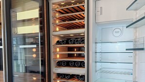A modern kitchen with a built-in wine cooler, a glass-fronted refrigerator, and a marble countertop. - Villa Emanuele Costarainera: wonderful modern villa, for 16 ppl, with garden, heated pool, hot-tub (Costarainera)