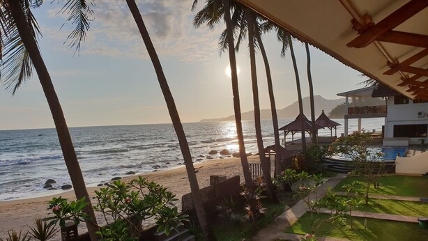 A beach view with palm trees, a pool, and a gazebo. - 77 Sunset Plaza (Cisolok)