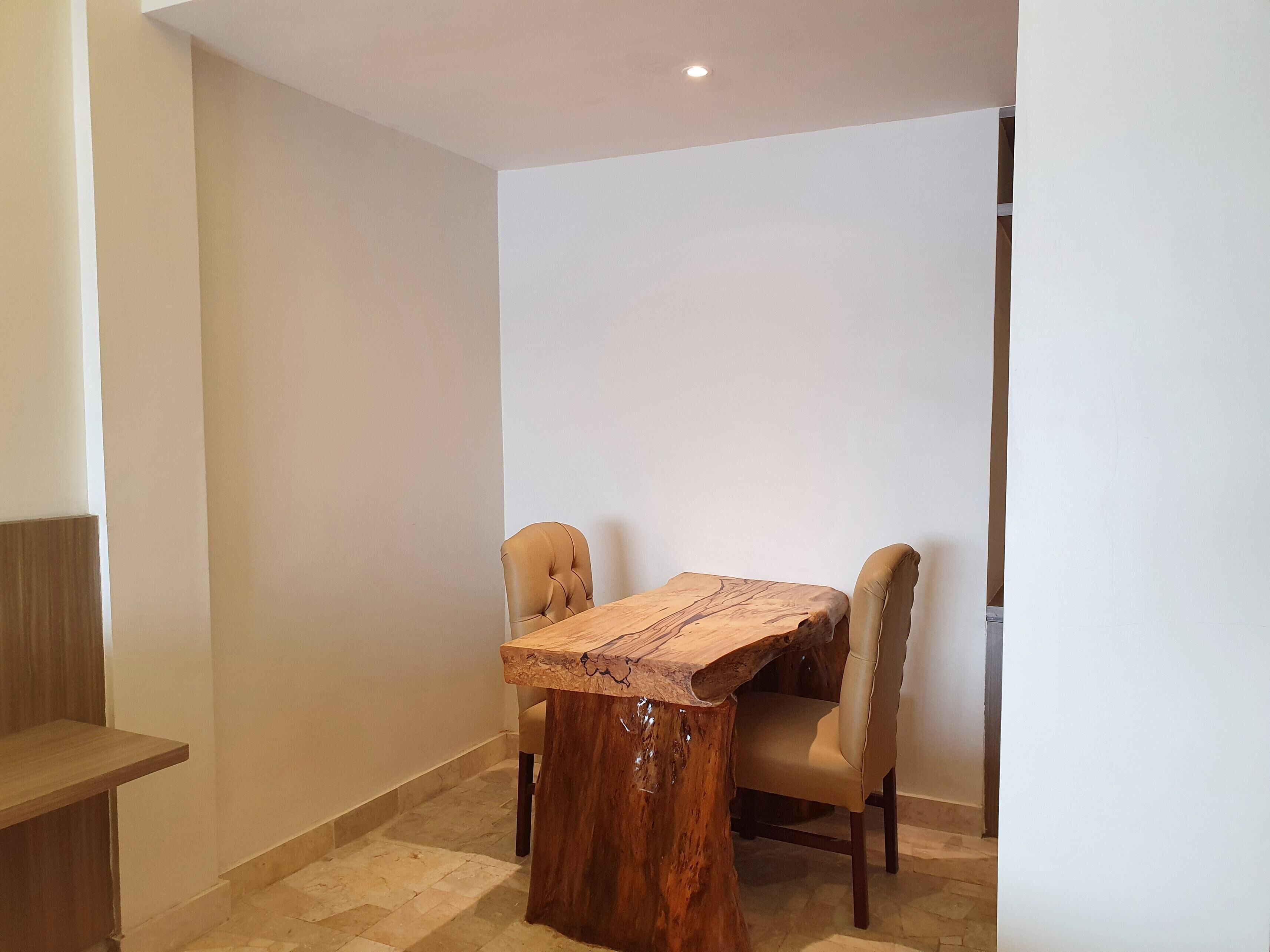 Een eetgedeelte met een houten tafel en twee stoelen.
