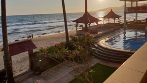 A beachside pool area with a view of the ocean and a sunset. - 77 Sunset Plaza (Cisolok)