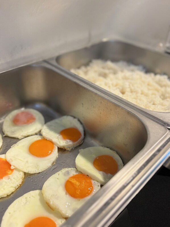 Un plateau contenant des œufs cuits et du riz.