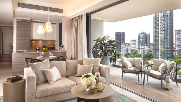A modern living room with a sofa, coffee table, and chairs. There is a dining area with a table and chairs. A large window offers a view of the cityscape. - Fraser Residence Orchard, Singapore (Singapore)