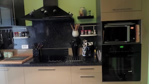 A kitchen with a black stove, microwave, and oven, with cabinets and a countertop.