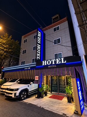 A hotel with a sign reading 'Swiss Hotel' and a car parked in front. - Hotel Swiss  (Seoul)