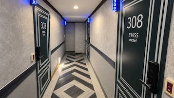 Pasillo de hotel con puertas numeradas 303 y 308, ambas identificadas como hotel suizo.