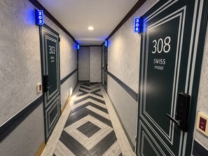 A hotel corridor with doors numbered 303 and 308, both labeled as Swiss hotel. - Hotel Swiss  (Seoul)