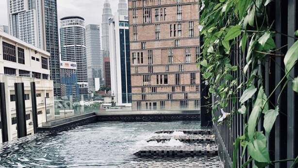 A rooftop pool with a cityscape view, surrounded by buildings including a hotel and a high-rise. - Gallipoli Anggun Suites (Kuala Lumpur)
