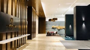 A modern hotel lobby with a reception desk, seating area, and a pool. - Gallipoli Anggun Suites (Kuala Lumpur)