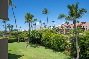 A hotel with multiple buildings, palm trees, and well-maintained lawns.