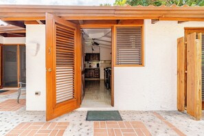 A house with a wooden door leading to a kitchen with cabinets and a ceiling fan. - Golf Villa 70 - Casa de Campo - Lake and Golf View- Maid Cook Wifi - Near Beach (La Romana)