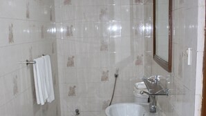 A bathroom with a toilet, sink, and mirror. - Aristocrat Inn (Dhaka)