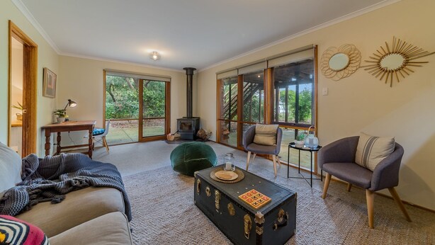 A cozy living room with a sofa, armchair, and a vintage suitcase as a coffee table. - Florida Trees - Wifi Incl (INVERLOCH)