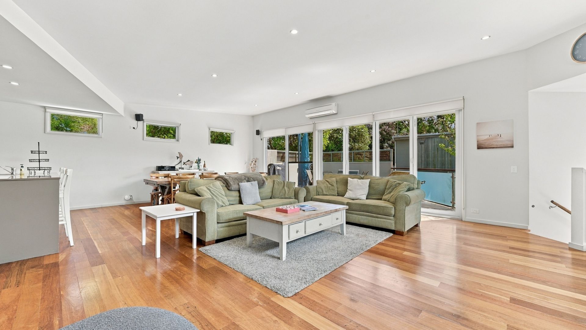A spacious living area with a kitchen, a dining table, and a sofa set.