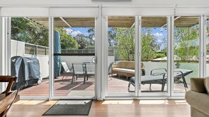 Un patio techado con una puerta corrediza de vidrio que da a un espacio exterior.