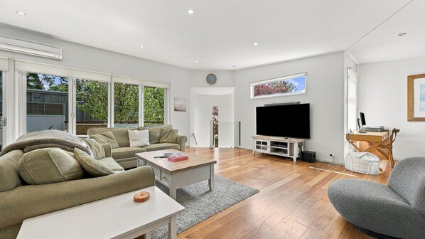 A modern living room with a sofa, coffee table, and TV.
