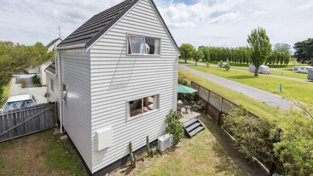 Ett envåningshus med ett sadeltak, en liten veranda och ett väl synligt fönster.