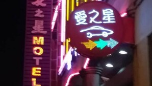 A neon sign for a motel with Chinese characters and a directional arrow. - Love Star Motel (Taoyuan City)