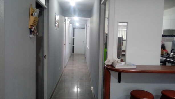 A narrow hallway with a kitchen area on the right, featuring a sink and stools. - THE HOUSE OF JOSE Second Floor  (Cuzco)