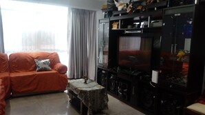 A living room with a sofa, a coffee table, a TV, and a cabinet with various items. - THE HOUSE OF JOSE Second Floor  (Cuzco)