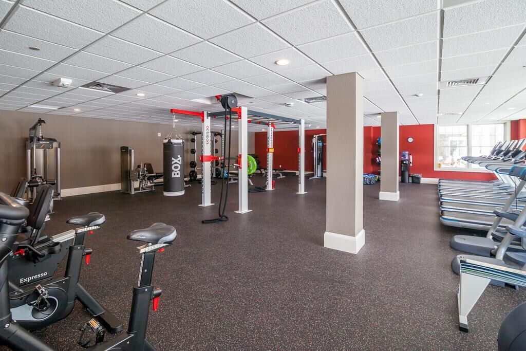 A gym with cardio machines, weightlifting equipment, and treadmills.