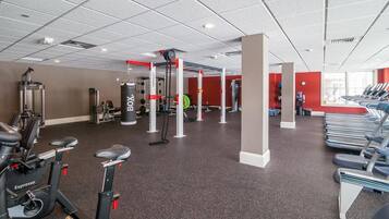 A gym with cardio machines, weightlifting equipment, and treadmills.