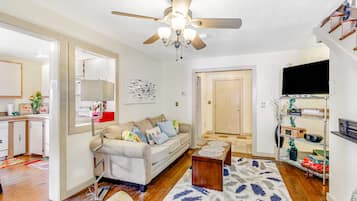 Relax in this open-plan living space with a sofa, coffee table, and TV.