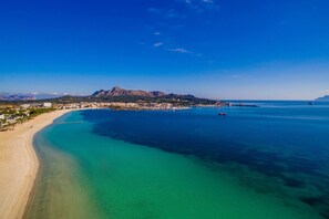 A coastal town with a beach, clear blue waters, and a mountain in the background. - House mountain view Lago Miguel in Alcudia (Alcúdia)