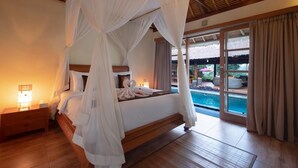 A four-poster canopy bed with a view of a swimming pool. - Ubud Serendipity Villa (Ubud)