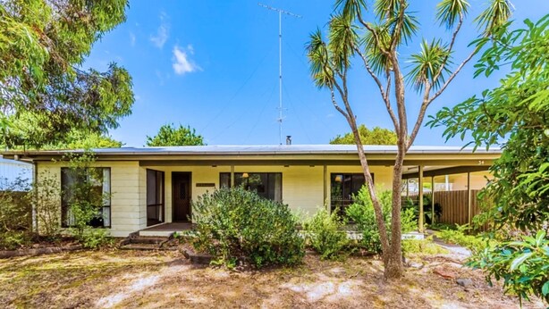 A single-story house with a flat roof, a front porch, and a small front yard with a tree and shrubs. - Driftwood On Anderson - Free Wifi (INVERLOCH)