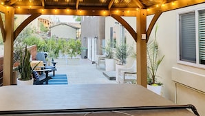 Eine überdachte Terrasse mit Sitzgelegenheiten und Topfpflanzen.