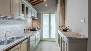 A kitchen with a granite countertop, stainless steel sink, and a view of the outside through a glass door. - Stunning private villa with A/C, hot tub, WIFI, private pool, TV, patio and panoramic view (Monsummano Terme)