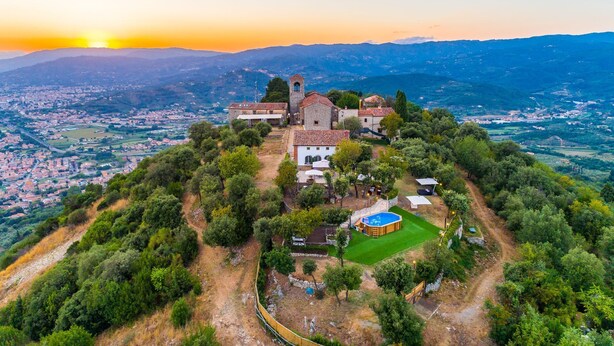 An aerial view of a historic building complex with a church, a bell tower, and surrounding greenery. - Stunning private villa with A/C, hot tub, WIFI, private pool, TV, patio and panoramic view (Monsummano Terme)