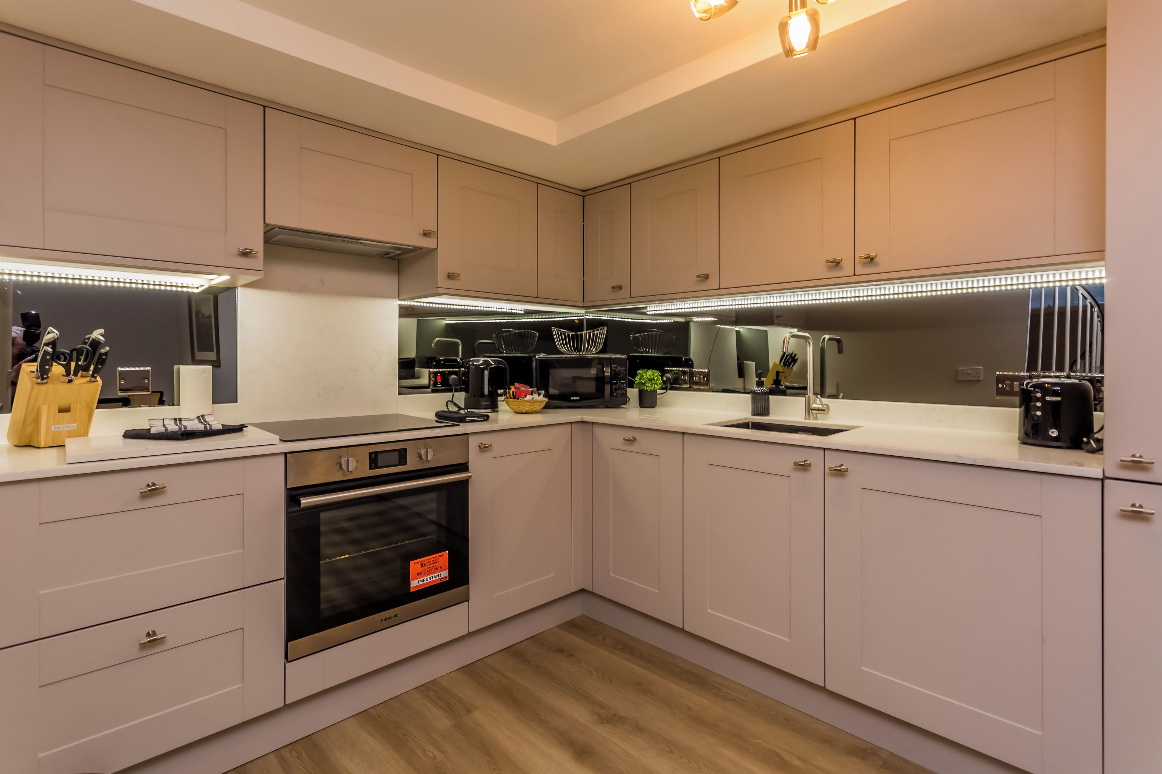 A modern kitchen with built-in appliances, a stainless steel oven, and a range hood.