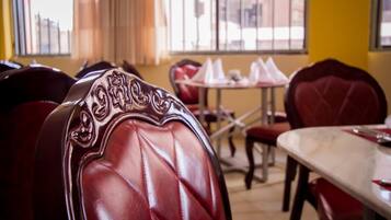 Un comedor con sillas tapizadas en rojo y una mesa de mármol.