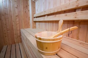 Un sauna en bois, avec un seau en bois et une louche en bois.