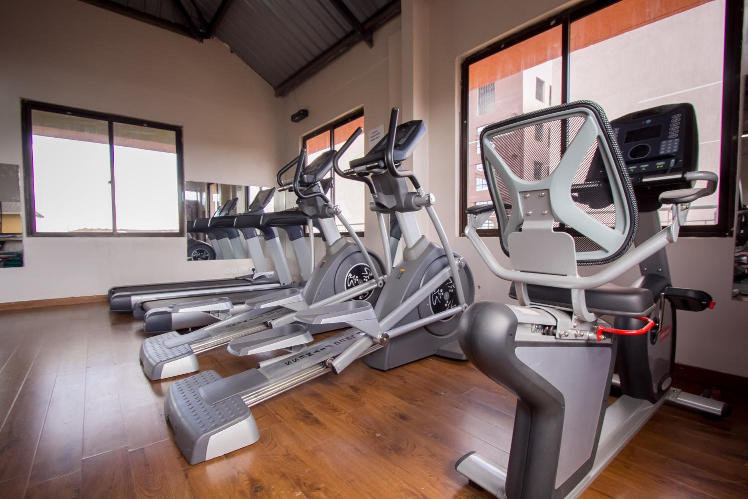 A gym with multiple treadmills and elliptical machines.