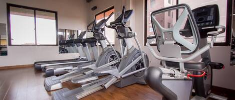 A gym with multiple treadmills and elliptical machines.