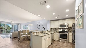 Una cocina moderna con armarios blancos, electrodomésticos de acero inoxidable y una isla grande.