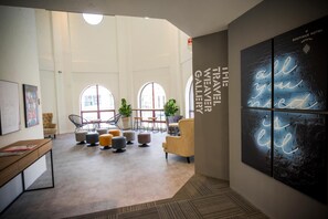 A modern hotel lobby with high ceilings, large windows, and a central seating area with ottomans and chairs. - H Boutique Hotel Xplorer Kota Damansara (Petaling Jaya)