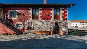 A building with a stone facade, a wooden staircase, and a clear sky. - Casa Ángela - country house in Villanueva de la Peña (Cantabria) | 6 guests (Villanueva De La Peña)