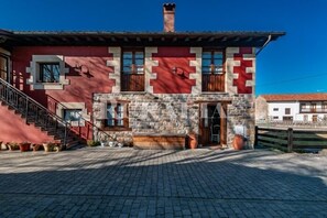 A building with a stone facade, a wooden staircase, and a clear sky. - Casa Ángela - country house in Villanueva de la Peña (Cantabria) | 6 guests (Villanueva De La Peña)