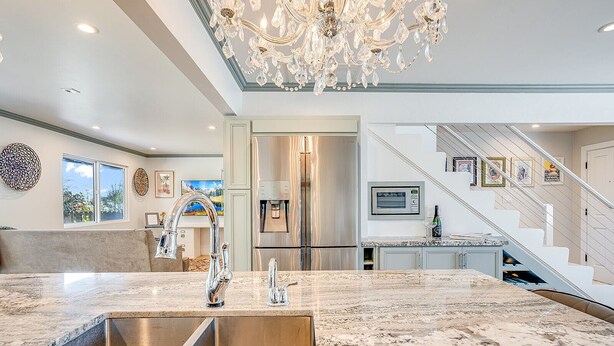 A modern kitchen with a marble countertop, stainless steel appliances, and a chandelier. - Luxurious, Spacious, Great Views, Minutes to Ocean (Aptos)