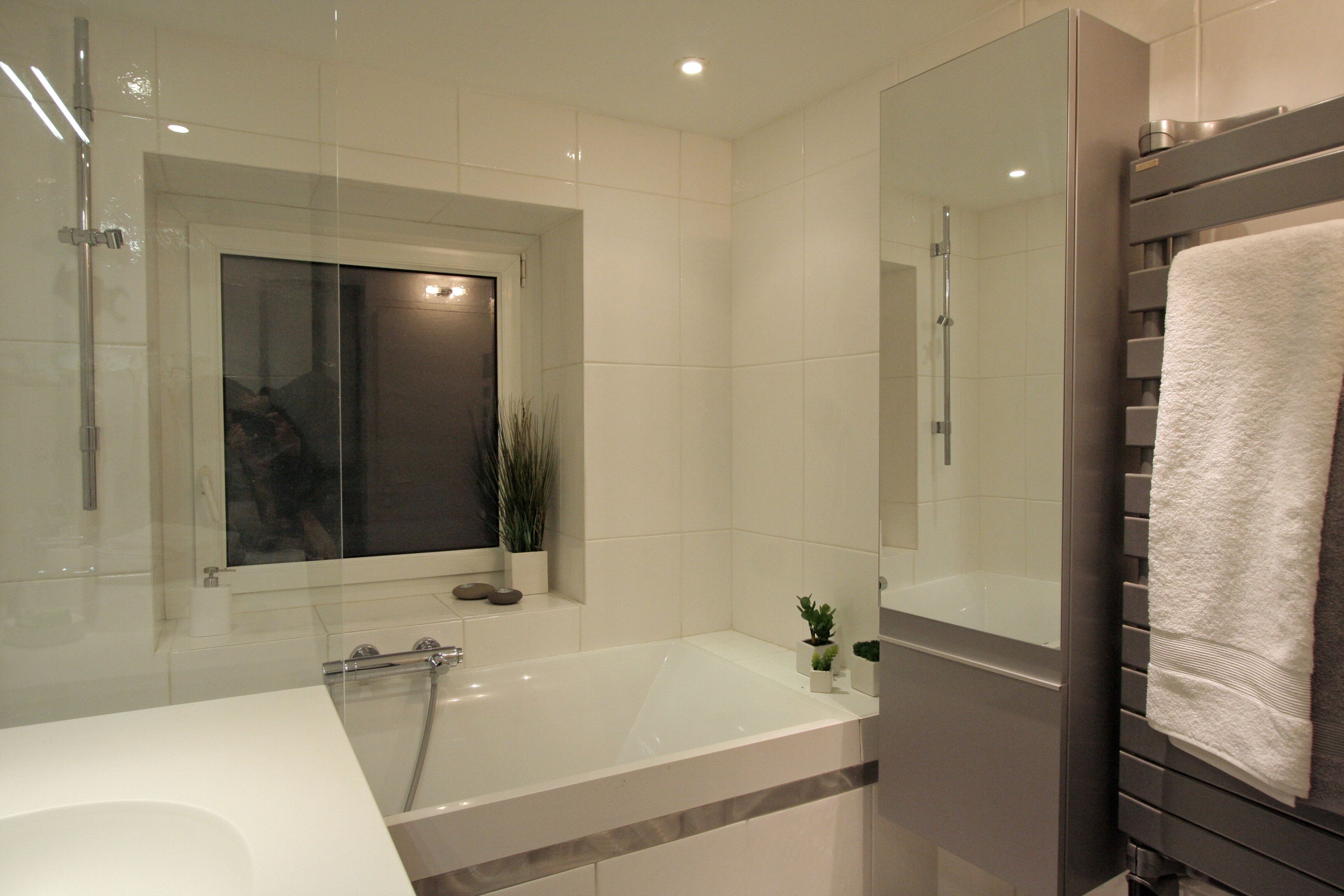 Ein modernes Badezimmer mit einer Badewanne, einer Duschkabine und einem großen Spiegel.