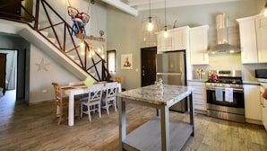A modern kitchen with white cabinets, stainless steel appliances, and a marble island. - 💕Tranquil Vibe with Your Own Private Pool💕Perfect Location! (Calabas)