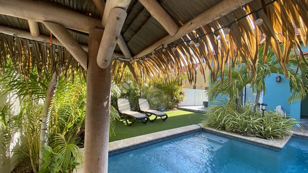 A pool area with a wooden pergola, lounge chairs, and tropical plants. - 💕Tranquil Vibe with Your Own Private Pool💕Perfect Location! (Calabas)