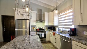 A modern kitchen with white cabinets, stainless steel appliances, and a granite countertop. - 💕Tranquil Vibe with Your Own Private Pool💕Perfect Location! (Calabas)